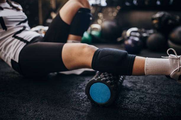 Woman foam rolling her leg after exercise, highlighting the need for compression socks for women's recovery.