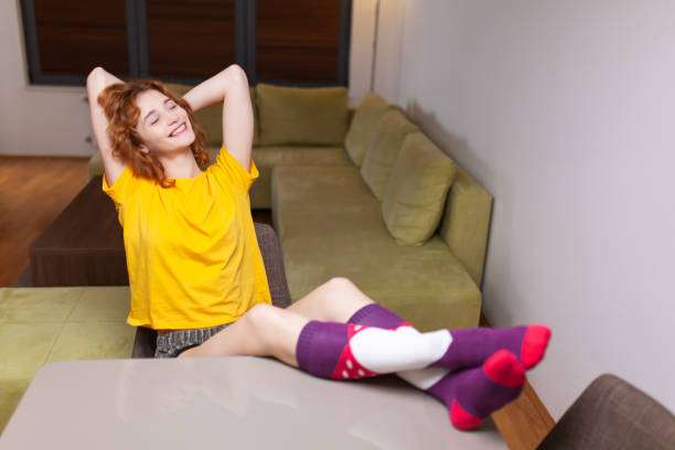 Happy woman relaxing with feet up, wearing comfortable compression socks for women.